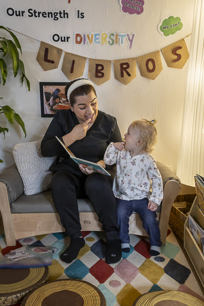 child care provider reads book with