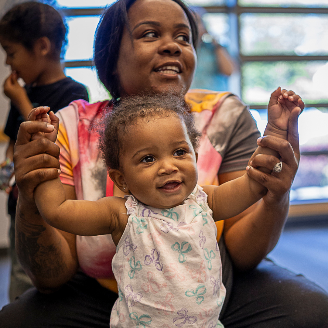 parent holds up baby's hands