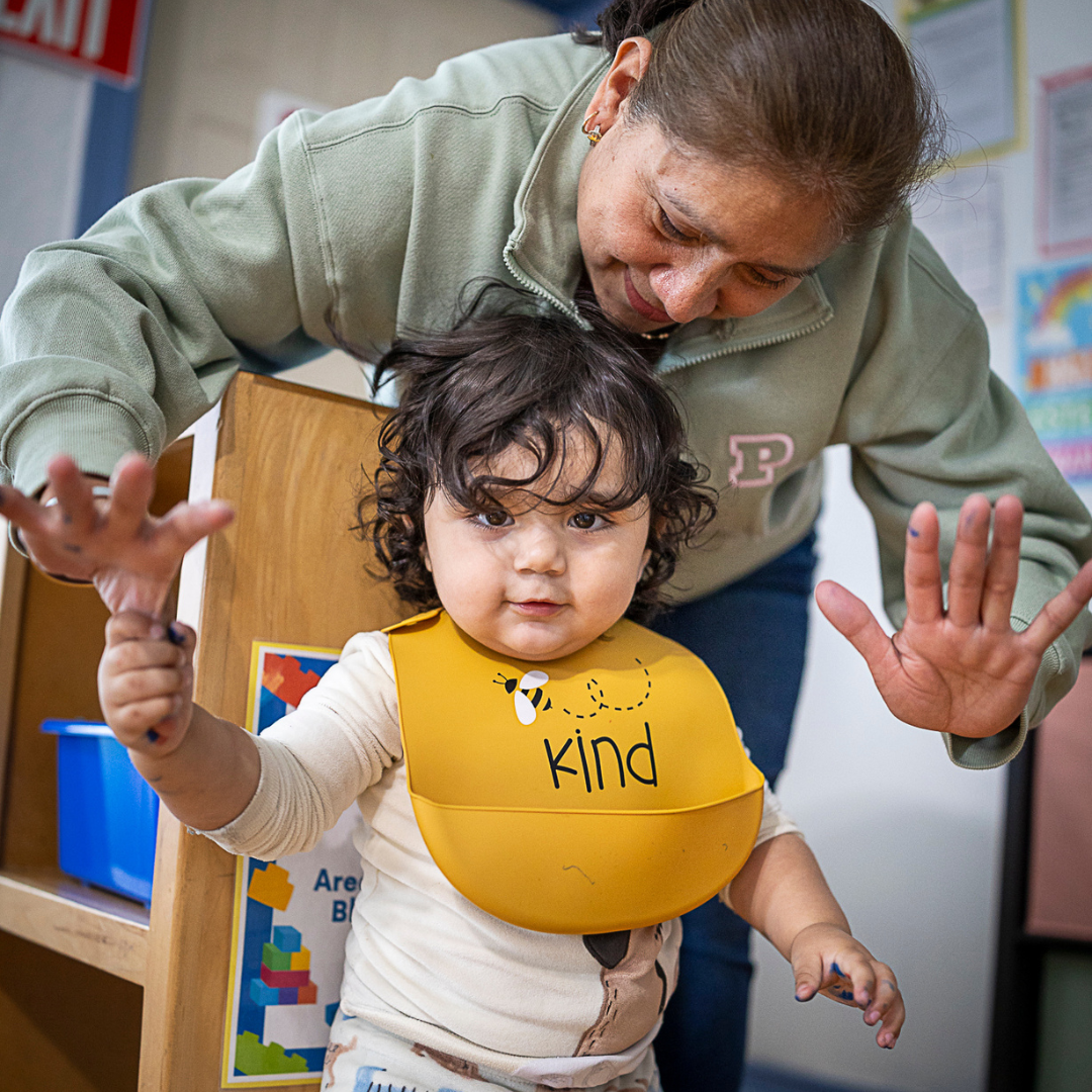 provider walks with child in bib